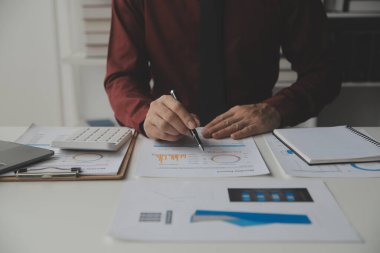 Hesap makinesi ve dizüstü bilgisayarı kullanarak ahşap masa, vergi, muhasebe, istatistik ve analitik araştırma konseptine matematik finansmanı sağlayan İş kadını kapat