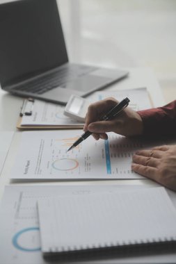 Hesap makinesi ve dizüstü bilgisayarı kullanarak ahşap masa, vergi, muhasebe, istatistik ve analitik araştırma konseptine matematik finansmanı sağlayan İş kadını kapat