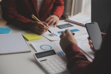 Hesap makinesi ve dizüstü bilgisayarı kullanarak ahşap masa, vergi, muhasebe, istatistik ve analitik araştırma konseptine matematik finansmanı sağlayan İş kadını kapat