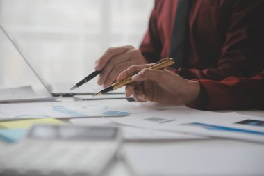 Hesap makinesi ve dizüstü bilgisayarı kullanarak ahşap masa, vergi, muhasebe, istatistik ve analitik araştırma konseptine matematik finansmanı sağlayan İş kadını kapat