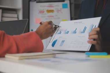 Hesap makinesi ve dizüstü bilgisayarı kullanarak ahşap masa, vergi, muhasebe, istatistik ve analitik araştırma konseptine matematik finansmanı sağlayan İş kadını kapat