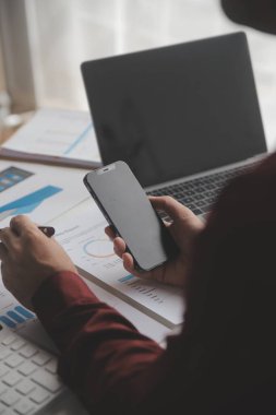 Hesap makinesi ve dizüstü bilgisayarı kullanarak ahşap masa, vergi, muhasebe, istatistik ve analitik araştırma konseptine matematik finansmanı sağlayan İş kadını kapat