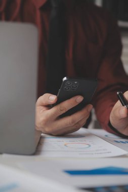 Hesap makinesi ve dizüstü bilgisayarı kullanarak ahşap masa, vergi, muhasebe, istatistik ve analitik araştırma konseptine matematik finansmanı sağlayan İş kadını kapat