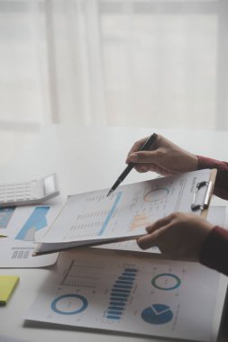 Hesap makinesi ve dizüstü bilgisayarı kullanarak ahşap masa, vergi, muhasebe, istatistik ve analitik araştırma konseptine matematik finansmanı sağlayan İş kadını kapat