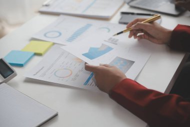 Hesap makinesi ve dizüstü bilgisayarı kullanarak ahşap masa, vergi, muhasebe, istatistik ve analitik araştırma konseptine matematik finansmanı sağlayan İş kadını kapat