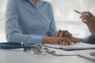 Genç bir kadın kalp ve akciğer kontrolü için kliniğe geliyor. Modern tıp bürosunda masasında oturan, steteskop tutan, hastanın nefesini ya da kalp atışlarını dinleyen ve gülümseyen dost canlısı bir bayan doktor.