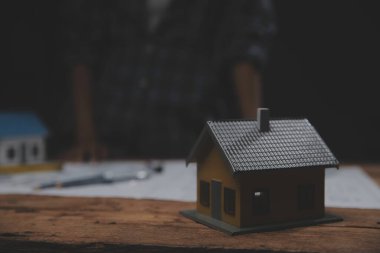 Toplantı odasında inşaat planları üzerinde çalışan çok ırklı mimarlardan oluşan bir ekip. Mühendisler ofiste proje üzerinde tartışıyorlar. Olgun iş adamı ve kadın masanın etrafında durmuş plan üzerinde çalışıyorlar..