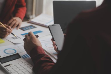 Hesap makinesi ve dizüstü bilgisayarı kullanarak ahşap masa, vergi, muhasebe, istatistik ve analitik araştırma konseptine matematik finansmanı sağlayan İş kadını kapat