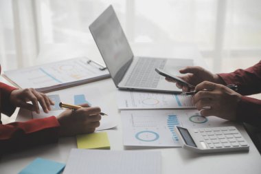 Hesap makinesi ve dizüstü bilgisayarı kullanarak ahşap masa, vergi, muhasebe, istatistik ve analitik araştırma konseptine matematik finansmanı sağlayan İş kadını kapat