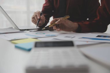 Hesap makinesi ve dizüstü bilgisayarı kullanarak ahşap masa, vergi, muhasebe, istatistik ve analitik araştırma konseptine matematik finansmanı sağlayan İş kadını kapat