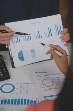 Hesap makinesi ve dizüstü bilgisayarı kullanarak ahşap masa, vergi, muhasebe, istatistik ve analitik araştırma konseptine matematik finansmanı sağlayan İş kadını kapat