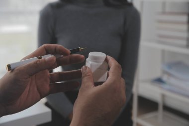 Asyalı doktor kadın, teşhis koymak ve evdeki ya da özel hastanedeki sağlığı kontrol etmek için hasta kadını ziyaret etti. Kadın hasta, sağlık sorununu ve belirtileri doktorlara açıklar.