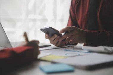 Hesap makinesi ve dizüstü bilgisayarı kullanarak ahşap masa, vergi, muhasebe, istatistik ve analitik araştırma konseptine matematik finansmanı sağlayan İş kadını kapat