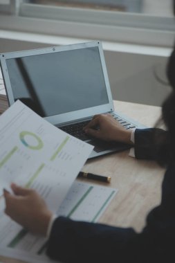 Hesap makinesi ve dizüstü bilgisayarı kullanarak ahşap masa, vergi, muhasebe, istatistik ve analitik araştırma konseptine matematik finansmanı sağlayan İş kadını kapat