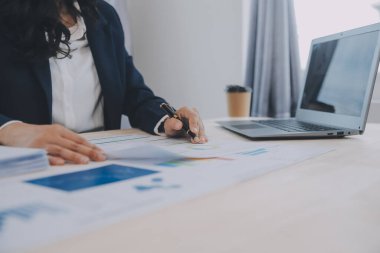 Hesap makinesi ve dizüstü bilgisayarı kullanarak ahşap masa, vergi, muhasebe, istatistik ve analitik araştırma konseptine matematik finansmanı sağlayan İş kadını kapat