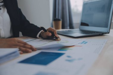Hesap makinesi ve dizüstü bilgisayarı kullanarak ahşap masa, vergi, muhasebe, istatistik ve analitik araştırma konseptine matematik finansmanı sağlayan İş kadını kapat