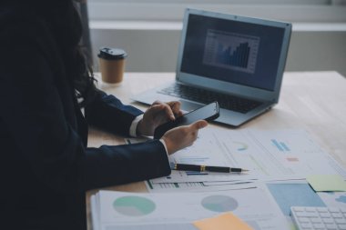 Hesap makinesi ve dizüstü bilgisayarı kullanarak ahşap masa, vergi, muhasebe, istatistik ve analitik araştırma konseptine matematik finansmanı sağlayan İş kadını kapat