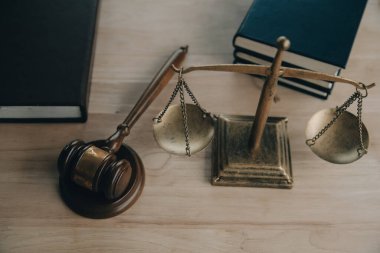 Adalet ve hukuk kavramı. Bir mahkeme salonunda tokmakla çalışan, bilgisayar ve kenetlenme klavyesi, gözlük takan bir erkek yargıç, sabah ışığında masada.
