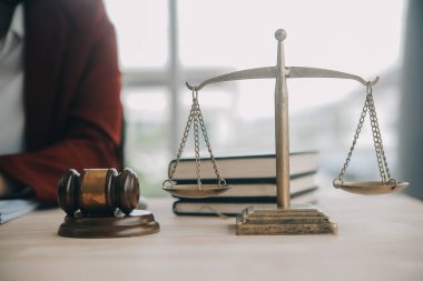 Adalet ve hukuk kavramı. Bir mahkeme salonunda tokmakla çalışan, bilgisayar ve kenetlenme klavyesi, gözlük takan bir erkek yargıç, sabah ışığında masada.