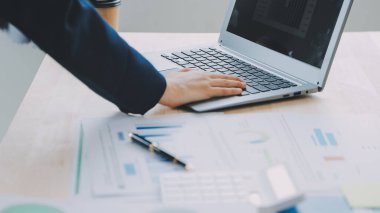 Hesap makinesi ve dizüstü bilgisayarı kullanarak ahşap masa, vergi, muhasebe, istatistik ve analitik araştırma konseptine matematik finansmanı sağlayan İş kadını kapat