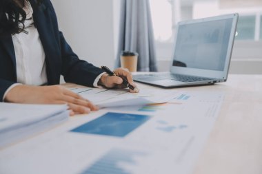 Hesap makinesi ve dizüstü bilgisayarı kullanarak ahşap masa, vergi, muhasebe, istatistik ve analitik araştırma konseptine matematik finansmanı sağlayan İş kadını kapat