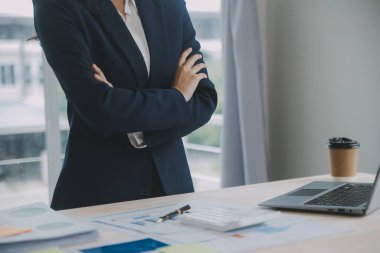 Hesap makinesi ve dizüstü bilgisayarı kullanarak ahşap masa, vergi, muhasebe, istatistik ve analitik araştırma konseptine matematik finansmanı sağlayan İş kadını kapat