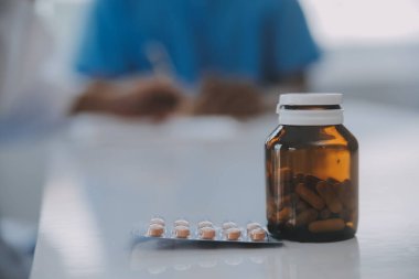 Doktor ve hasta klinikteki masada otururken sağlık muayenesini tartışıyorlar. Tıp konsepti.