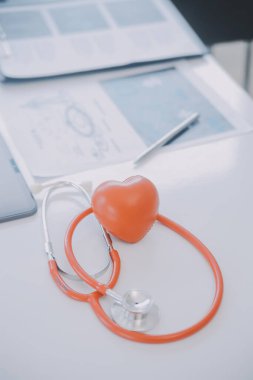 Çok ırklı tıbbi ekip, beyaz laboratuvar önlüklü ve ameliyat önlüklü doktorlarla toplantı yapıyor. Hasta kayıtlarını tartışıyorlar.