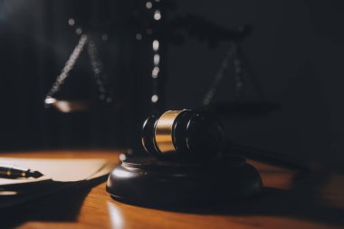 Hukuk bürosunun kütüphanesindeki hukuk kitapları ve adalet terazileri masanın üzerinde. Hukuk eğitimi kavramı.