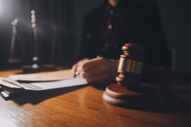 Hukuk bürosunun kütüphanesindeki hukuk kitapları ve adalet terazileri masanın üzerinde. Hukuk eğitimi kavramı.