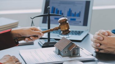 Adalet ve hukuk kavramı. Bir mahkeme salonunda tokmakla çalışan, bilgisayar ve kenetlenme klavyesi, gözlük takan bir erkek yargıç, sabah ışığında masada.