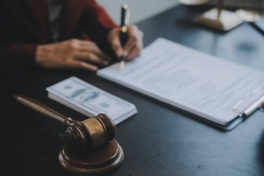Adalet ve hukuk kavramı. Bir mahkeme salonunda tokmakla çalışan, bilgisayar ve kenetlenme klavyesi, gözlük takan bir erkek yargıç, sabah ışığında masada.