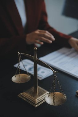 Adalet ve hukuk kavramı. Bir mahkeme salonunda tokmakla çalışan, bilgisayar ve kenetlenme klavyesi, gözlük takan bir erkek yargıç, sabah ışığında masada.