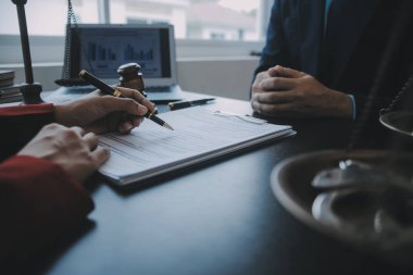 Adalet ve hukuk kavramı. Bir mahkeme salonunda tokmakla çalışan, bilgisayar ve kenetlenme klavyesi, gözlük takan bir erkek yargıç, sabah ışığında masada.