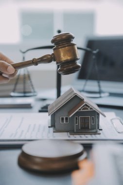 Adalet ve hukuk kavramı. Bir mahkeme salonunda tokmakla çalışan, bilgisayar ve kenetlenme klavyesi, gözlük takan bir erkek yargıç, sabah ışığında masada.