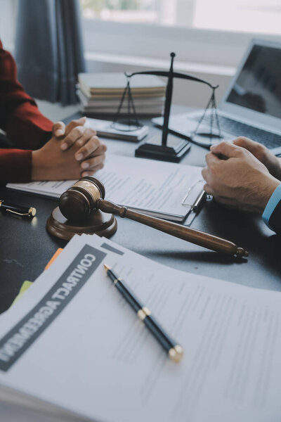 Justice and law concept.Male judge in a courtroom with the gavel, working with, computer and docking keyboard, eyeglasses, on table in morning light