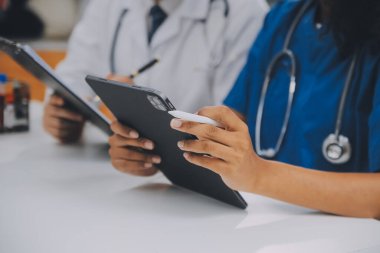 Tıbbi çalışan laboratuvar önlüğü ve steril maskesi arkasında çalışıyoruz onun meslektaşım süre mikroskop analiz yapıyor