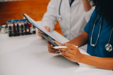 Tıbbi çalışan laboratuvar önlüğü ve steril maskesi arkasında çalışıyoruz onun meslektaşım süre mikroskop analiz yapıyor