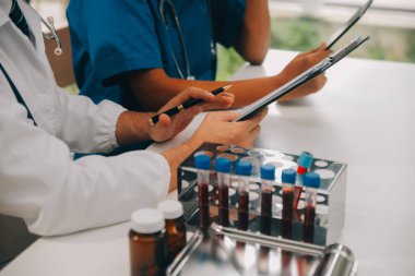 Tıbbi çalışan laboratuvar önlüğü ve steril maskesi arkasında çalışıyoruz onun meslektaşım süre mikroskop analiz yapıyor