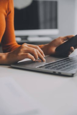 Asyalı iş kadını dizüstü bilgisayar kullanıyor ve ofiste hesap makinesi ile çalışıyor, mali raporu, iş planı yatırımını, mali analiz konseptini analiz etmeyi planlıyor..