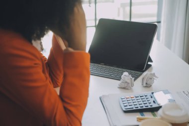 Yorgun ve Asyalı bir kadının portresi ofiste vergi bilgisayarıyla çalışıyor. Üzgün, mutsuz, endişeli, depresyon ya da çalışan hayatı stres konsepti