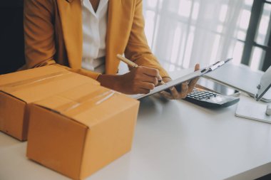 Kuruluş KOBİ küçük serbest Asyalı kadın girişimcisi kutulu bir dizüstü bilgisayar kullanarak mutlu Asyalı kadın elini online pazarlama paketlemesini kaldırdı ve KOBİ fikri sundu