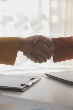 İş kadını eliyle grafiğe işaret ediyor ve bilgisayar ekranında liste yapmak için bir kalem kullanıyor