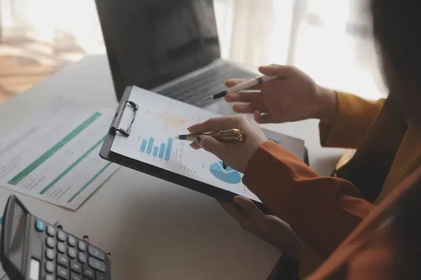 stock image business woman hand pointing at graph and using a pen to do list on computer screen