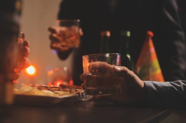 Kutlama gecesi, bardağa viski dök. Kutlamaya gelen arkadaşlarına ver.