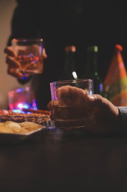 Kutlama gecesi, bardağa viski dök. Kutlamaya gelen arkadaşlarına ver.