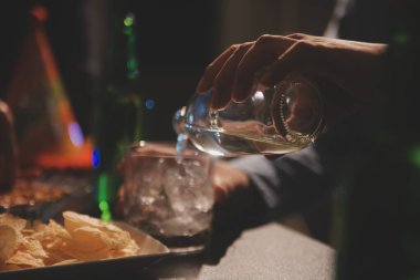 Kutlama gecesi, bardağa viski dök. Kutlamaya gelen arkadaşlarına ver.