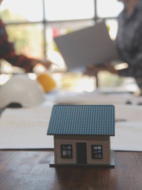 A team of construction engineers talks to managers and construction workers at the construction site. Quality inspection, work plan, home and industrial building design project