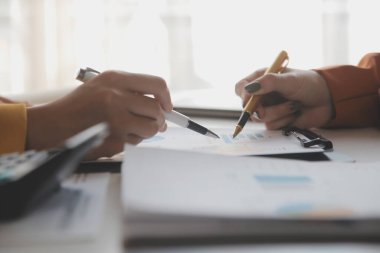 Dolma kalemle, defterle ve hesap makinesiyle çalışan kadın elleri