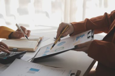 Ofiste finansal grafikle çalışan iş adamları